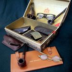 A case containing his glasses and pipes